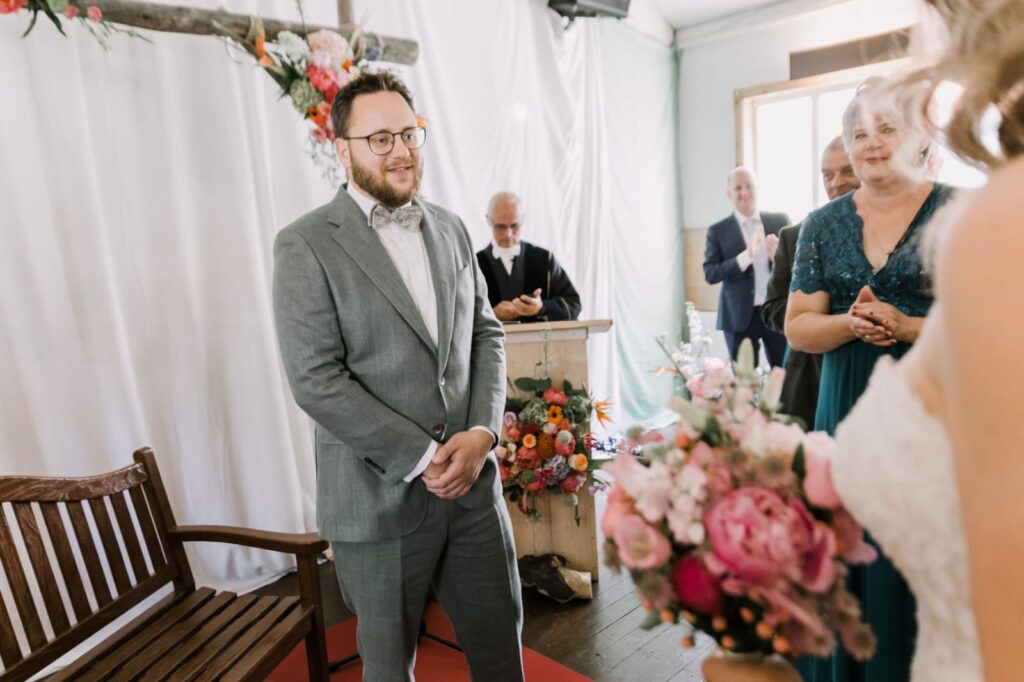 Man met groen pak voor altaar