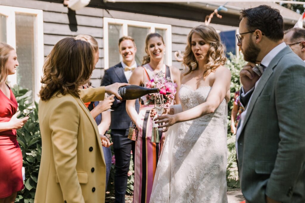 Vrouw in witte jurk man met groen pak schenken drinken in