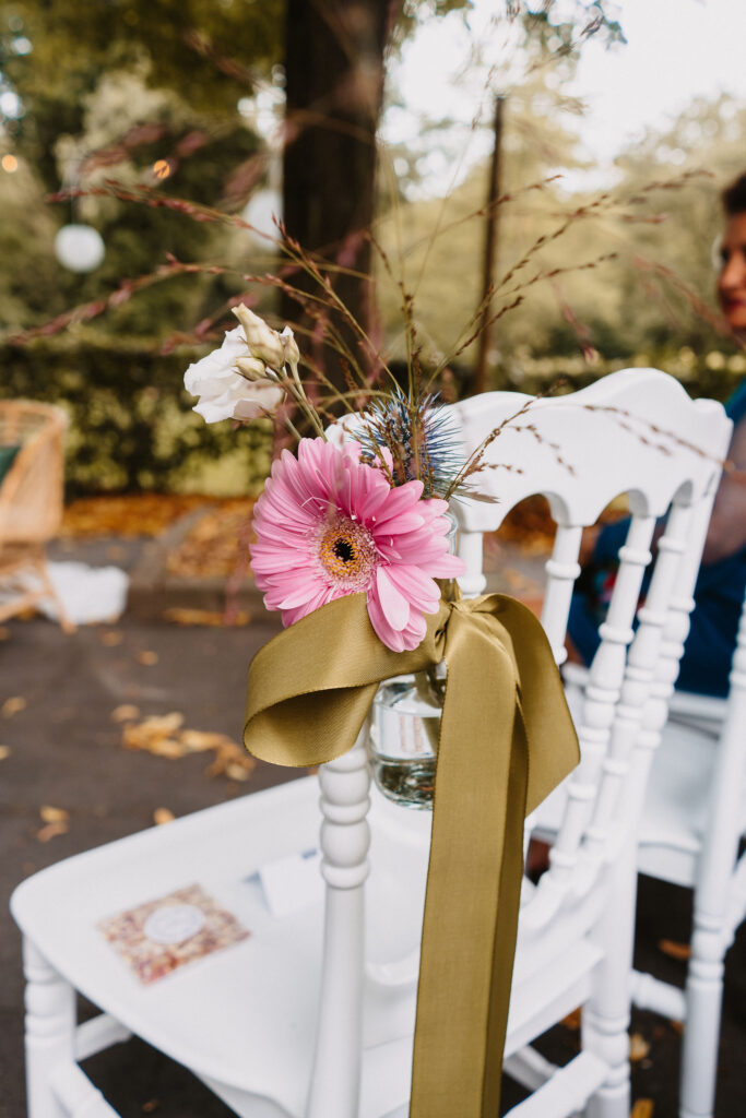 Styling bloemen aan stoel met strik