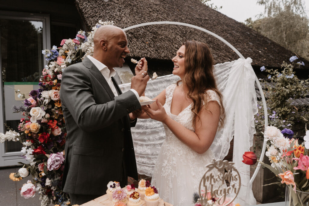Bruidspaar met gekleurde bruidstaart met bloemen