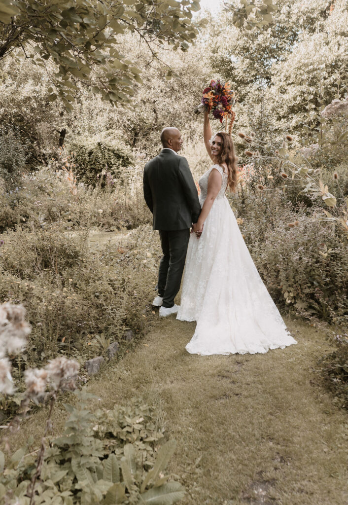 Bruidspaar met roze en oranje bruidsboeket