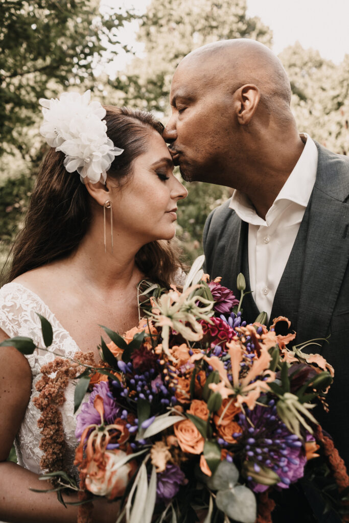 Bruidspaar met roze oranje bruidsboeket